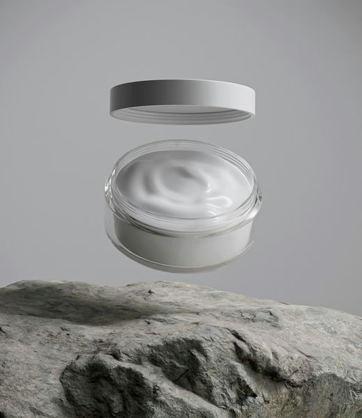 Barrier Cream in a clear glass jar, its lid lifted above a stone.