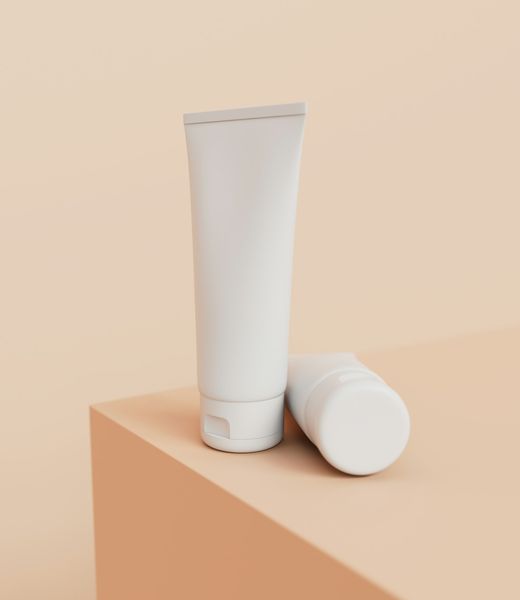 Oat Milk Cleanser in a soft white tube on a peach-colored block.